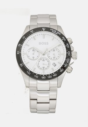 Reloj cronógrafo de acero inoxidable plateado con una esfera blanca, bisel negro, tres subesferas y ventana de fecha. Cuenta con una pulsera de eslabones pulidos.