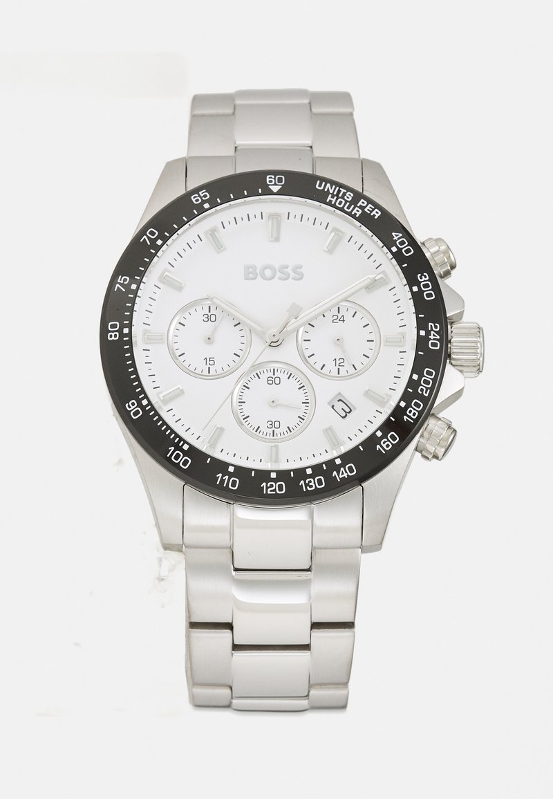 Reloj cronógrafo de acero inoxidable plateado con una esfera blanca, bisel negro, tres subesferas y ventana de fecha. Cuenta con una pulsera de eslabones pulidos.