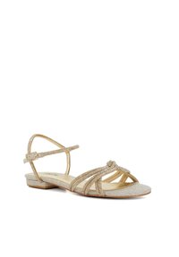 Gold-colored sandal with a textured fabric upper, featuring decorative bead accents, an open toe design, and an adjustable ankle strap.