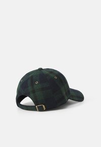 Grønn og marineblå rutete caps laget av ull, med en buet skygge, justerbar stropp bak og gullfargede detaljer.