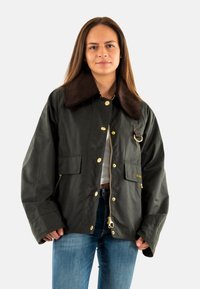 Dunkelgrüne wasserfeste Jacke mit einem braunen Cordkragen, goldenen Druckknöpfen, zwei Fronttaschen und einer seitlichen Reißverschlusstasche.