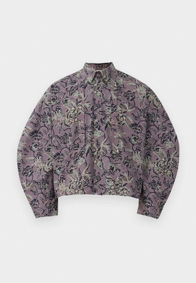 Gekürzte Hemdbluse aus lila Stoff mit floralen und blättrigen Mustern in Grün und Schwarz. Verfügt über einen spitzen Kragen und gefaltete Vorderseite.