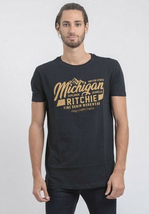 T-shirt en coton noir avec un design doré portant l'inscription "Michigan" accompagné de graphiques de montagnes et de détails de marque. Manches courtes et col rond.