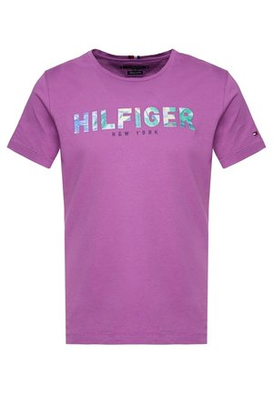 T-shirt violet à manches courtes et col rond avec l'inscription "HILFIGER NEW YORK" imprimée sur la poitrine en lettres multicolores.