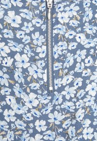 Floral zippered fabric featuring a blue background with light blue and white flowers, accented by hints of brown. Textured surface.