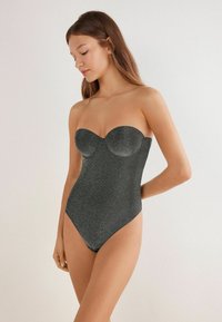 Jednoczęściowy, czarny kostium kąpielowy bez ramiączek, wykonany z błyszczącego materiału, z dopasowanym gorsetem i wysokimi wycięciami nogawek. Gładka tekstura i jednolity design.