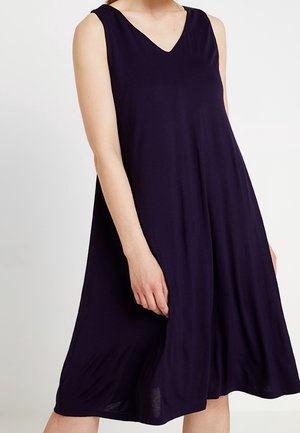 Sukienka bez rękawów, sięgająca do kolan, w ciemnym fioletowym kolorze, z dekoltem w kształcie litery V, miękkim, drapowanym materiałem oraz luźnym krojem rozszerzającym się przy dolnym brzegu.