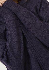 Ciemnofioletowy dziergany sweter z wzorem w romby, ściągaczami na rękawach i przytulną fakturą, o luźnym kroju.