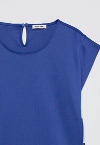 Blue short-sleeve top with round neckline and back keyhole button closure, labeled Salsa Jeans.