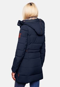Geacă puffer bleumarin cu glugă cu fermoar, design matlasat și căptușeală din blană sintetică. Include un patch din piele cu logo și buzunare pe laterale.