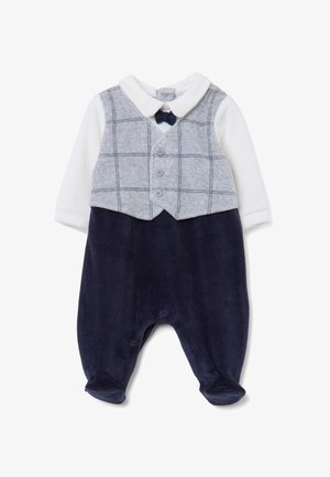 Marineblauwe corduroy tuinbroek met een grijs geruit vest, witte lange mouwen en een marineblauwe strik. Voorzien van knoopsluiting en drukkers aan de onderkant.