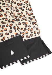 Vadderad ytterkläder i beige tyg med svarta och orange leopardfläckar. Svart nederdel med en raketlogotyp och rutigt kantband vid fållen.