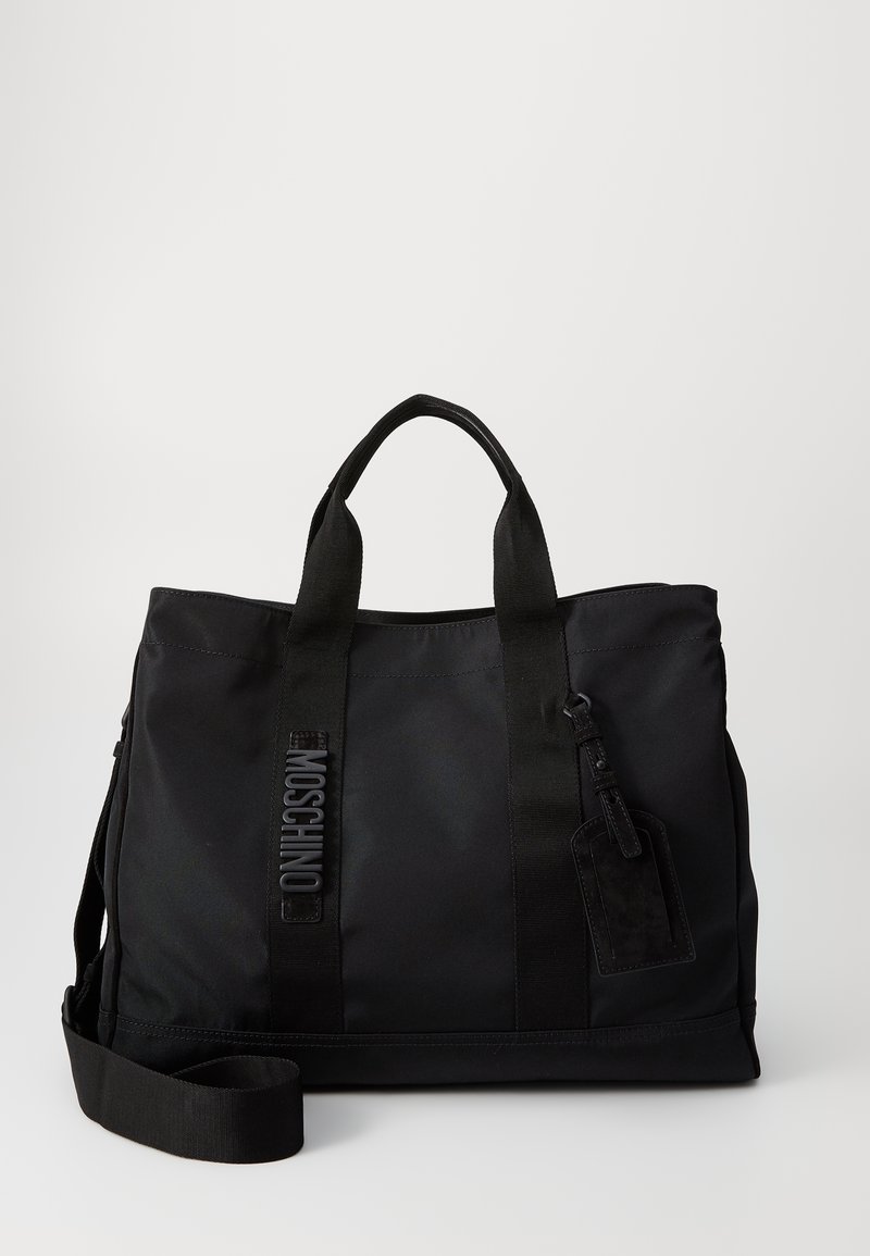 Fekete nylon bevásárlótáska dupla felső fogantyúval, állítható vállpánttal és dombornyomott logóval. Simább textúrájú, címke csatlakozással.