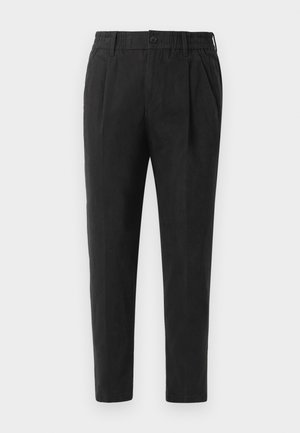 Schwarze tapered Hosen mit glatter Textur, elastischem Bund, Knopfverschluss und vorderen Falten, entworfen für eine enganliegende Passform.