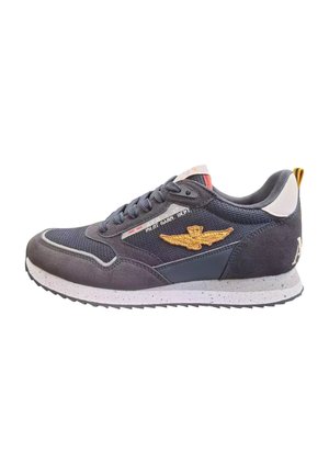 Sneaker grigio realizzato in mesh e suede, con un logo ad ala ricamato in oro, suola bianca maculata e lacci blu.