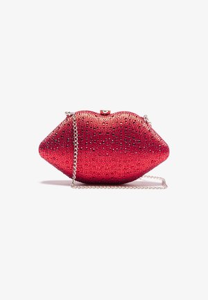 Rote clutch in Lippenform, bedeckt mit kleinen Strasssteinen und mit silbernem Kettenriemen auf weißem Hintergrund.