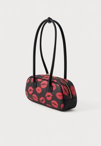 Borsa nera con impronte di labbra rosse, due manici neri e chiusura con zip. Materiale testurizzato con forma arrotondata e dettagli in zip dorata.