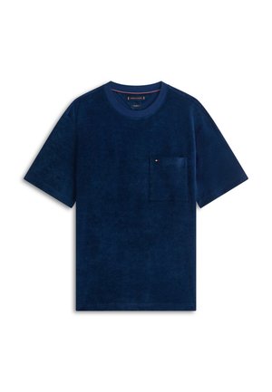 Camiseta azul marino de manga corta con cuello redondo y bolsillo en el pecho que presenta un pequeño logo en rojo, blanco y azul.