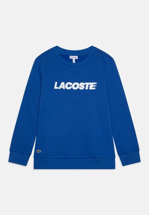 Sweatshirt bleu en mélange de coton, avec un col rond, des manches longues et le logo « LACOSTE » sur la poitrine. Poignets et ourlet côtelés.