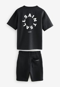 Camiseta negra de manga corta con estampado circular "ALLSAINTS LONDON" y pantalones cortos negros a juego con bolsillo trasero etiquetado "ALLSAINTS".