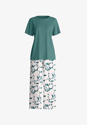 Chemise à manches courtes couleur sarcelle associée à un pantalon à jambes larges avec un motif floral blanc et rose clair sur un fond vert foncé.