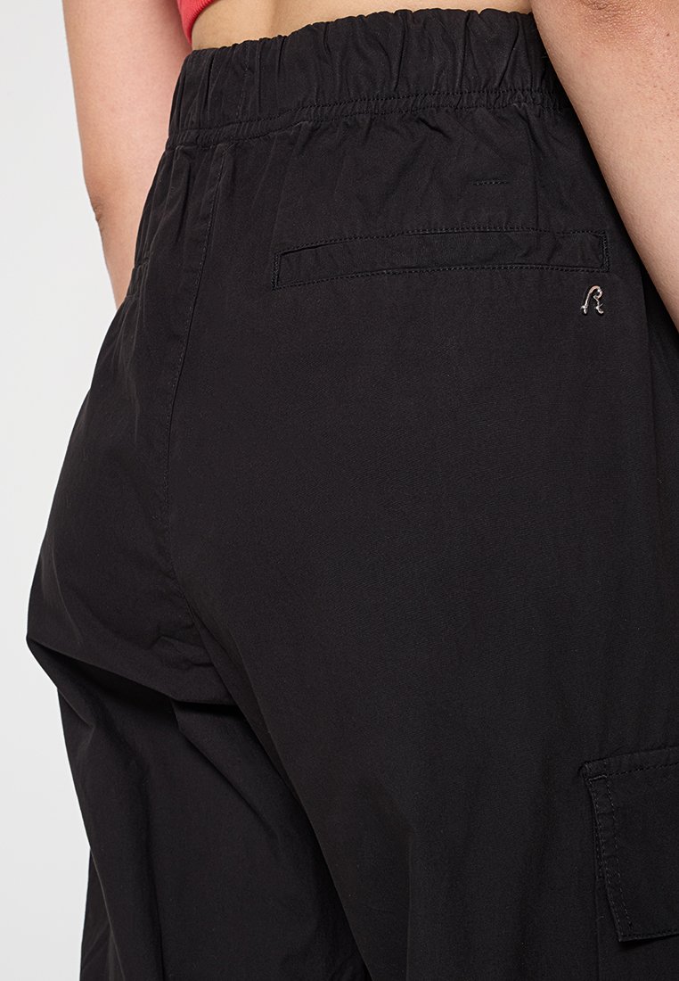 Pantaloni cargo neri con finitura testurizzata, dotati di una vita elasticizzata, tasche laterali e una tasca posteriore sul lato destro.