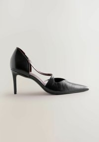 Cizmă de piele neagră, cu toc înalt, vârful ascuțit, design cu decupaje pe laterale, finisaj strălucitor și toc subțire stil stiletto.