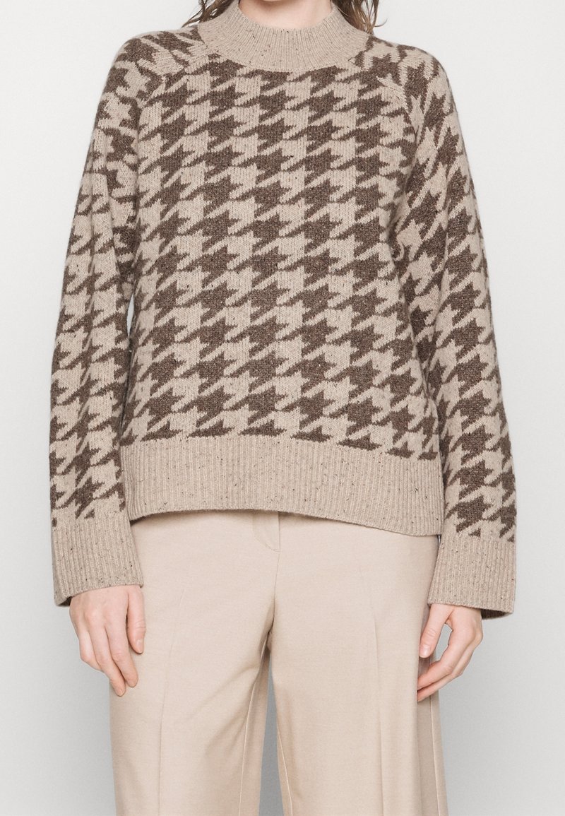 Beige Strickpullover mit einem Hahnentritt-Muster in Dunkelbraun, ausgestattet mit einem gerippten Rundhalsausschnitt und breiten gerippten Bündchen.