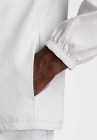 Lichtgewicht witte jas met elastische manchetten en zijzak, met een soepele textuur en schone naden.