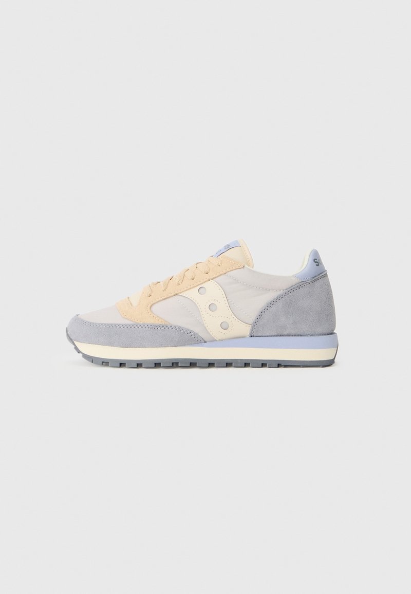 Baskets basses beige, gris clair et crème avec des accents en suède et une semelle en caoutchouc texturée, vues de profil sur un fond uni.