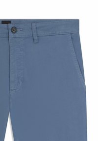 Helleblaue Hose aus glattem Stoff mit einem Knopfverschluss, Seitentaschen und kontrastierenden Nähten entlang der Ärmel.