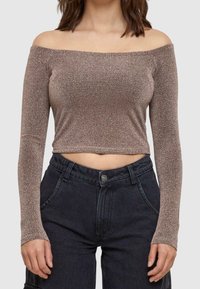 Off-shoulder, långärmad topp med kort längd i ett glittrande bronsefärgat tyg. Designen har en tät passform och en texturerad, ribbad material.