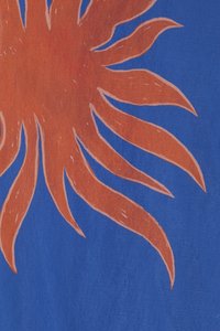 Il tessuto presenta uno sfondo blu brillante con un grande sole stilizzato arancione, caratterizzato da raggi allungati e linee bianche di accento.