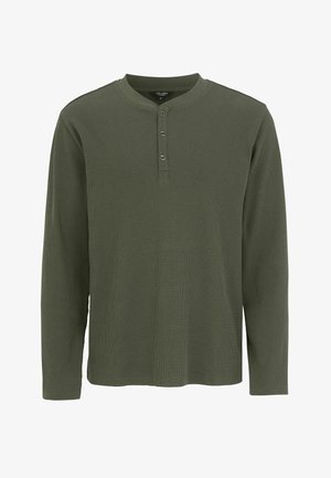 Langærmet henley skjorte i olivengrøn, struktureret stof med vaffelmønster, tre-knaps stolpe og rund halsudskæring.