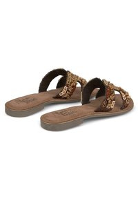 Sandales plates marron avec un design de bride perlée, doublure intérieure douce et semelle texturée, idéales pour un usage décontracté.