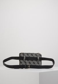 Bolso de mano con un estampado negro y gris, con correa ajustable negra, forma rectangular, textura suave y acentos de hardware en tono plateado.