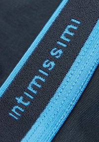 Schwarzer Stoff mit strukturierter Oberfläche zeigt ein gesticktes blaues Logo "Intimissimi" auf einem kontrastierenden blauen Band.