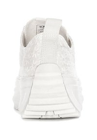 Białe trampki z teksturowaną cholewką w kwiatowy wzór oraz wyściełanym paskiem na pięcie. Podeszwa ma wyraźnie zaznaczone żłobienia zapewniające przyczepność.