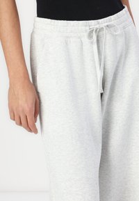 Lyse grå sweatpants med elastisk talje og snøre. Stoffet har en blød struktur, har sidelommer og en afslappet pasform.