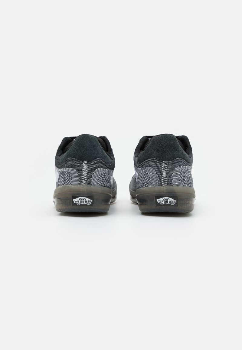 Zapatillas deportivas en negro y gris con parte superior de malla y ante, cuentan con un collarín acolchado, suela de goma y el logo de Vans en el talón.