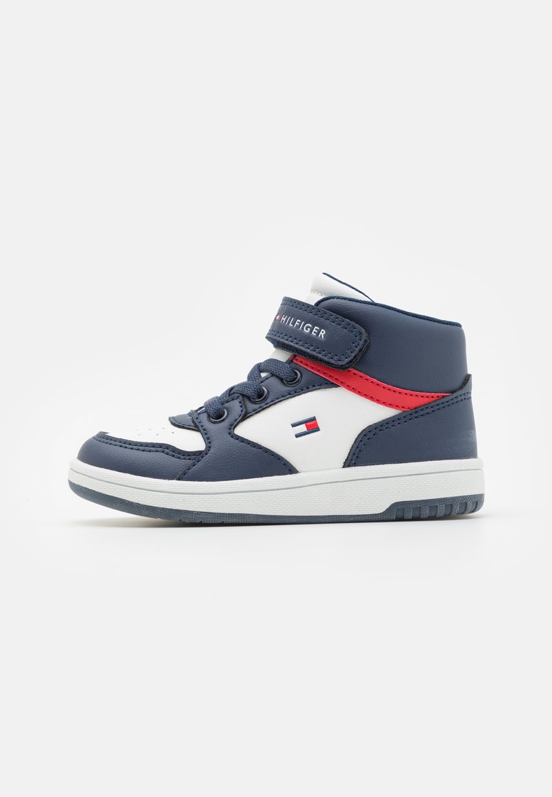 Zapatillas altas de color azul marino con detalles en blanco, cuero texturizado, correa ajustable y detalles en rojo. Incluye una suela plana y exhibición del logo.