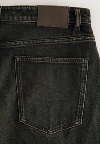Sorte denim jeans med en baglomme med diskret syning, en struktureret lædermærke og en tætsiddende pasform.