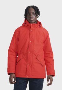 Rote isolierte Jacke mit Kapuze, ausgestattet mit einem vorderen Druckknopfverschluss, zwei Fronttaschen und einem glatten, wasserabweisenden Stoff.