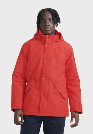 Chaqueta aislante roja con capucha, que presenta un cierre frontal a presión, dos bolsillos frontales y un tejido suave y resistente al agua.