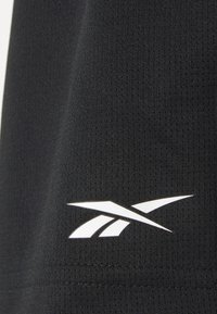 Schwarzer Sportstoff mit strukturiertem Oberfläche; zeigt ein weißes Reebok-Logo an der Seite. Einfaches, eng anliegendes Design.