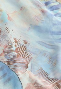 Tissu doux avec des motifs abstraits aquarellés en tons pastel de bleu, rose et marron, comportant des détails fins de lignes horizontales et diagonales.