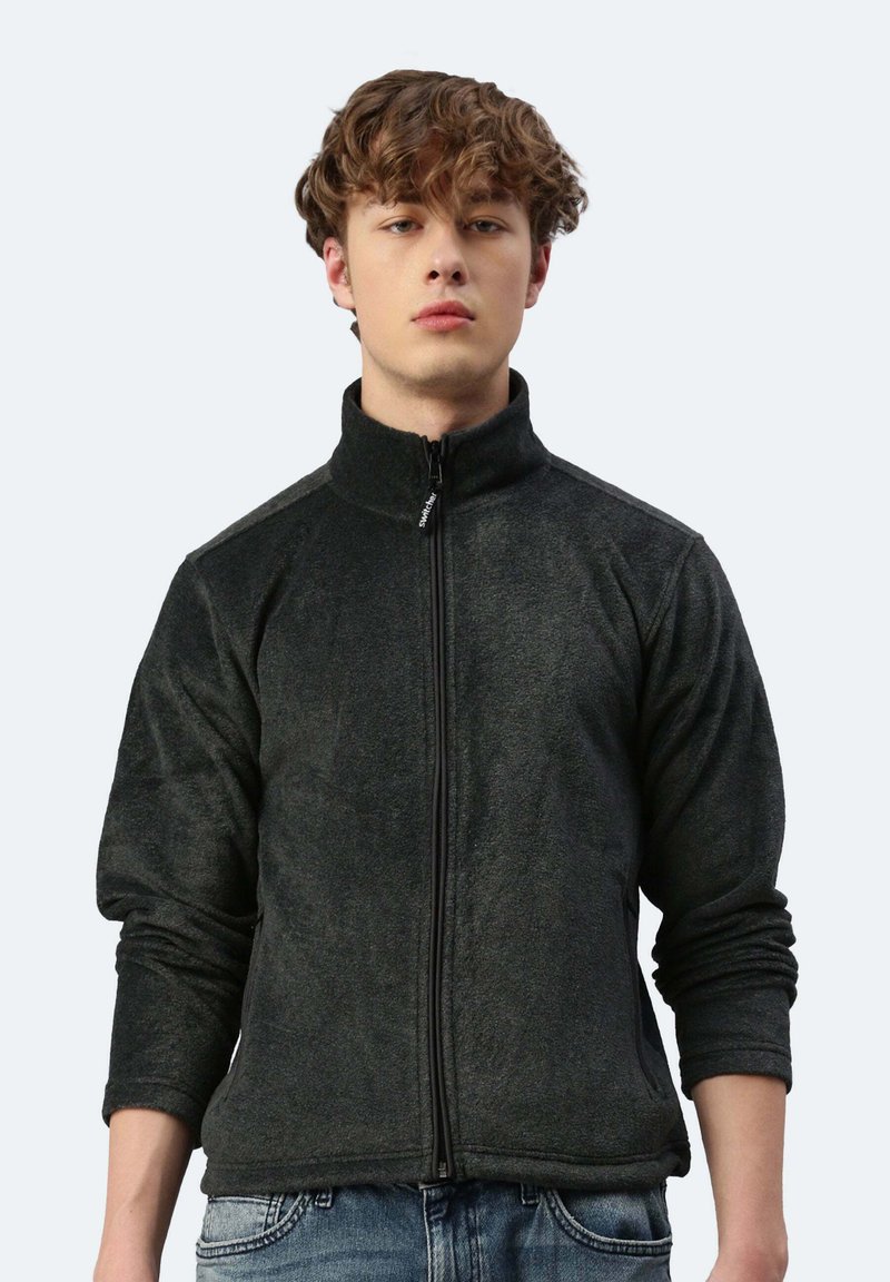 Schwarze Fleecejacke mit hohem Kragen, vollwertigem Reißverschluss und langen Ärmeln. Verfügt über eine leicht strukturierte Oberfläche und Seiten Taschen.