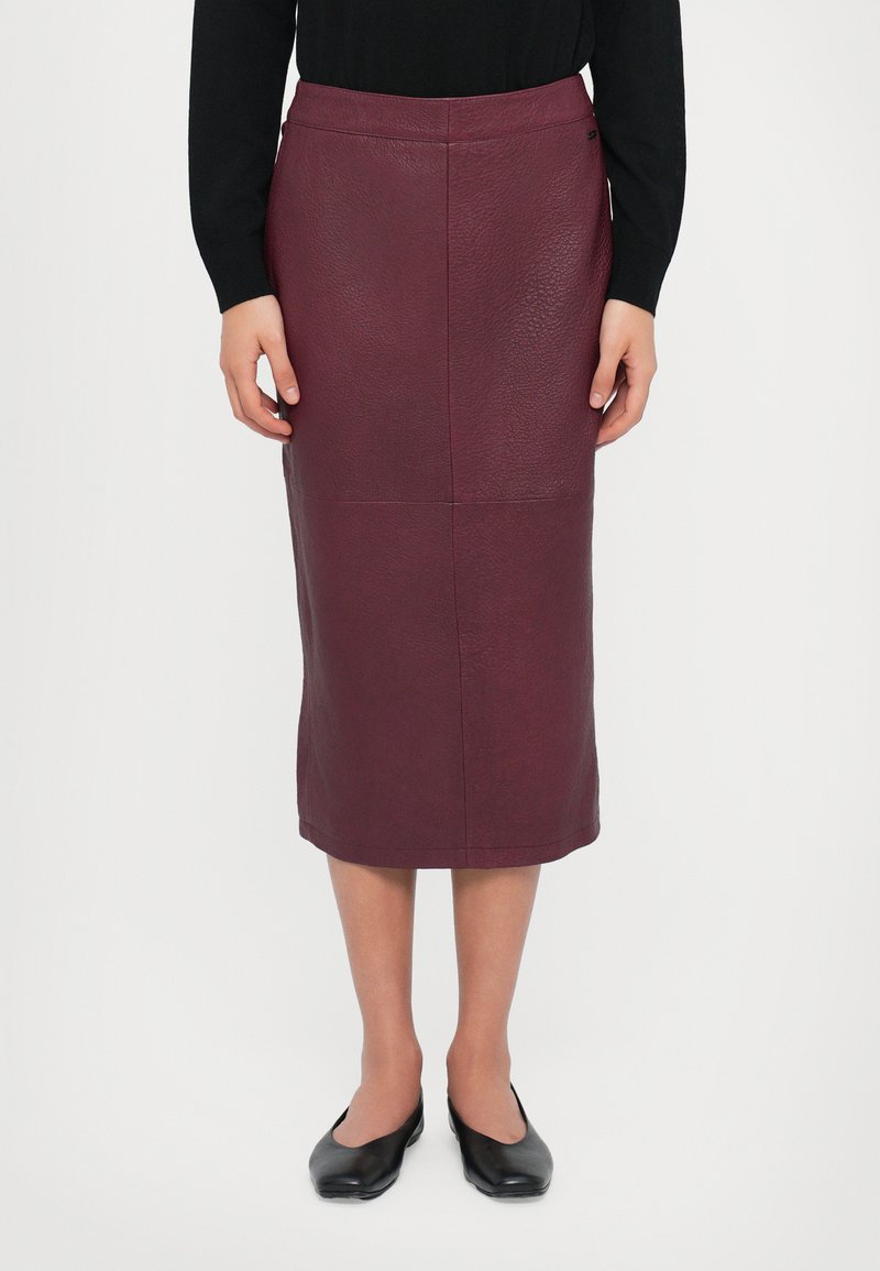 Jupe crayon en cuir bordeaux à finition texturée, longueur genou, avec une taille ajustée et des détails de couture subtils.