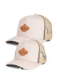 Beige-lakki, jossa on verkkotakakappale,  jossa on ruskea keinonahkainen patch, jossa lukee "BLACKSKIES PREMIUM SUPPLIES". Kaareva lippa ja säädettävä koko.