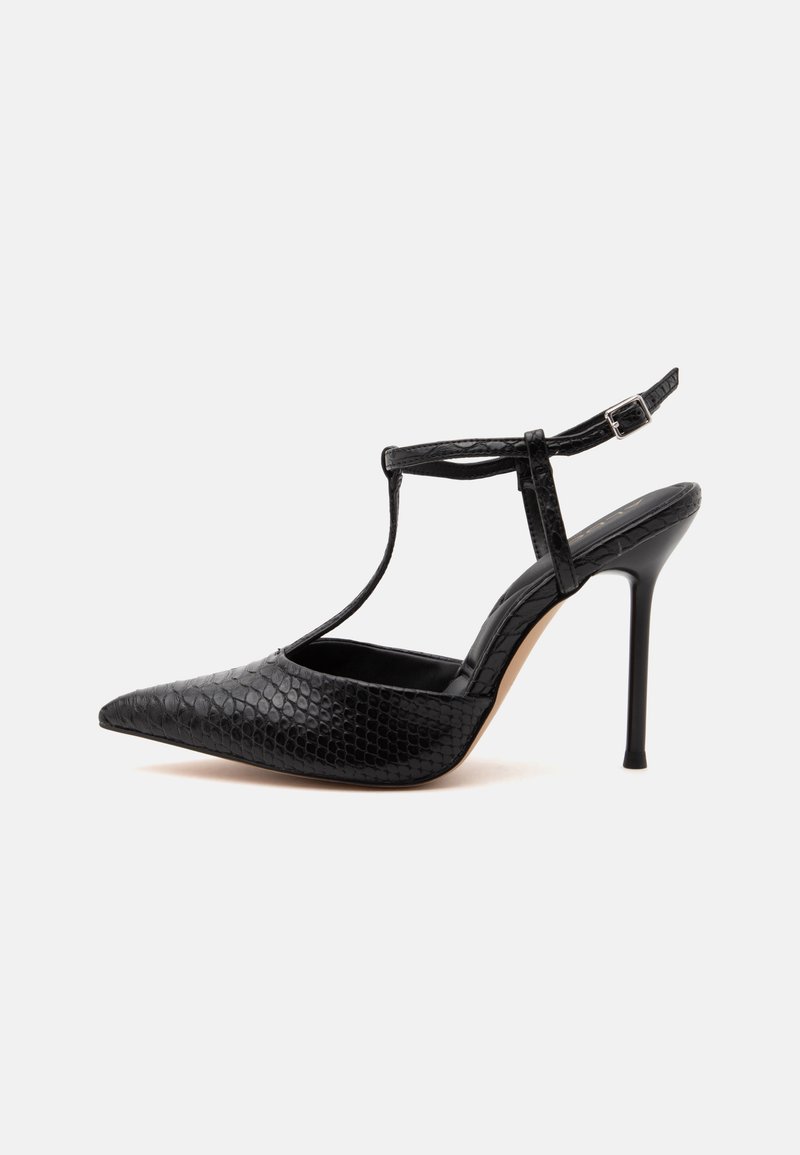 Chaussure noire à talon haut avec bout pointu, motif crocodile texturé, talon stiletto fin et bride de cheville avec boucle.